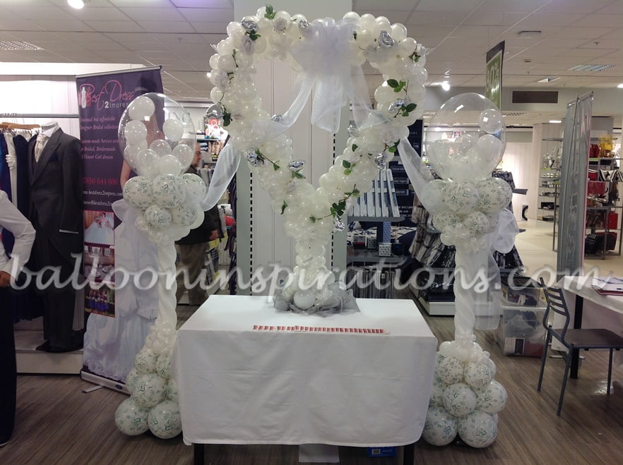 Floral balloon columns with balloon heart sculpture